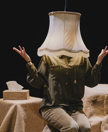 Image du spectacle "Sans faire de bruit" une personne qui a la tête dans un abat jour
