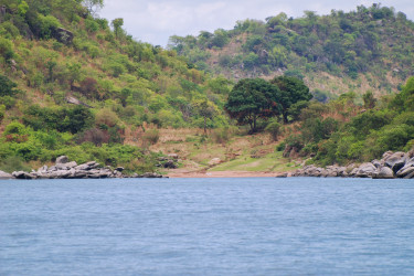 Lake Tanganyika shoreline, sandy beach surrounded by boulders 