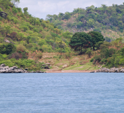 Lake Tanganyika shoreline, sandy beach surrounded by boulders 