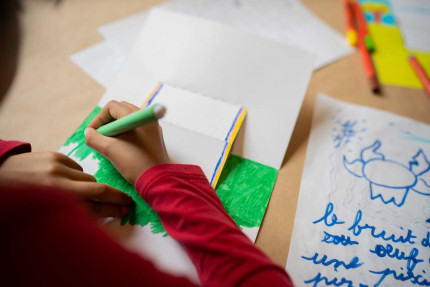 Enfant qui colorie son carnet